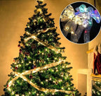 Decorated Christmas tree with golden ribbon lights, ornaments, and stockings hanging by fireplace