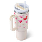 White travel tumbler with handle, pink and red heart pattern, clear lid and straw
