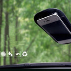 Black car side mirror with mounted smartphone holder against green blurred background