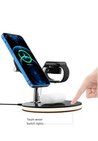 Black wireless charging station with blue smartphone, smart watch, and white earbuds, finger touching sensor