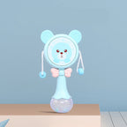 Blue baby hand drum toy with bear face, pink bow, and textured clear base on table