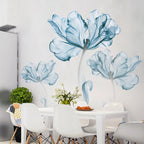 Modern dining area with white table, chairs, blue floral wall decals, and decorative greenery