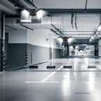 Empty modern underground parking garage with bright LED security lights and marked parking spaces