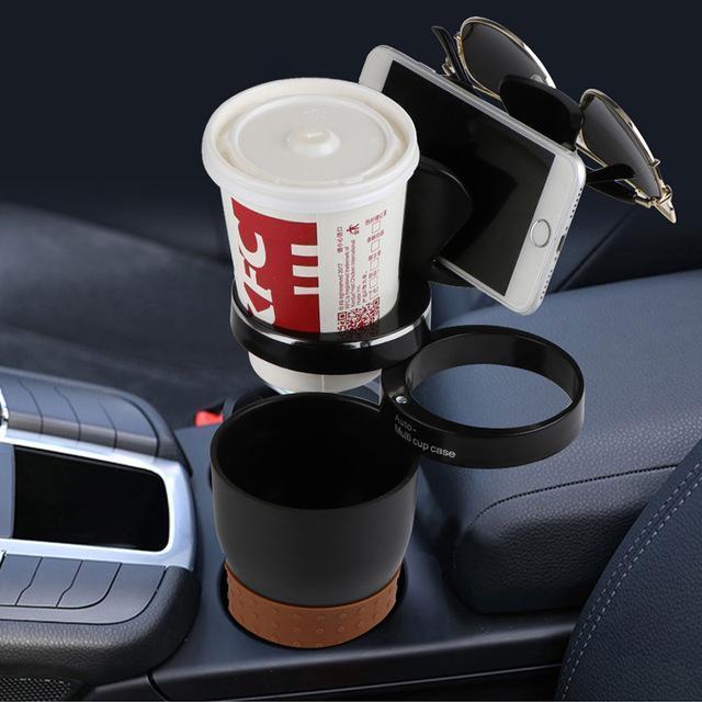 Car cup holder with KFC drink, phone holder with sunglasses, and black cup on car center console