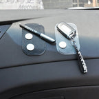 Car dashboard with two sticky anti-slip mats holding a marker pen, coins, and a key fob with a black keychain