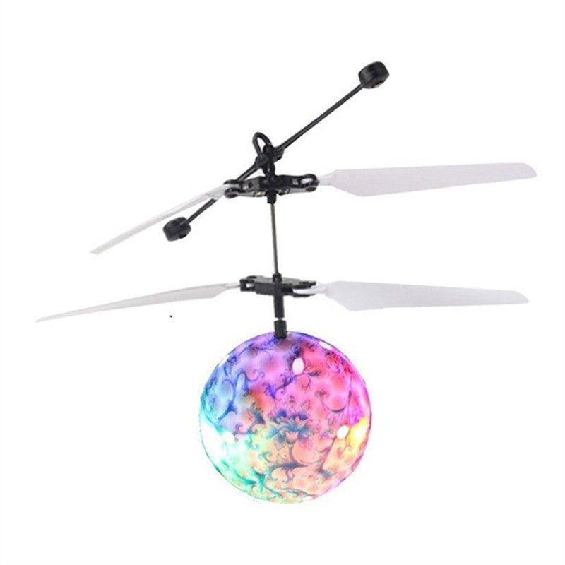 Colorful glowing flying ball toy with white rotor blades and black frame isolated on white