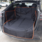 Black waterproof pet car seat cover with orange trim installed in the open trunk of a black SUV