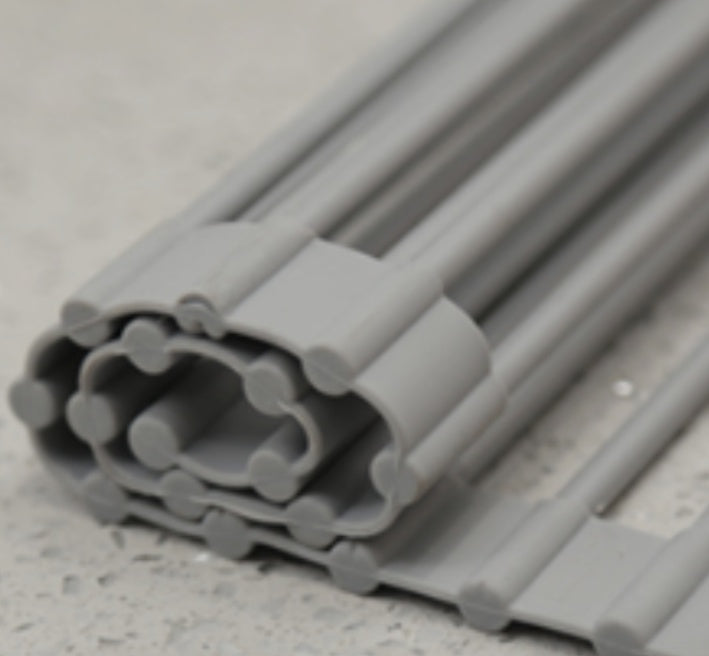 Close-up of flexible gray silicone drying rack on speckled countertop