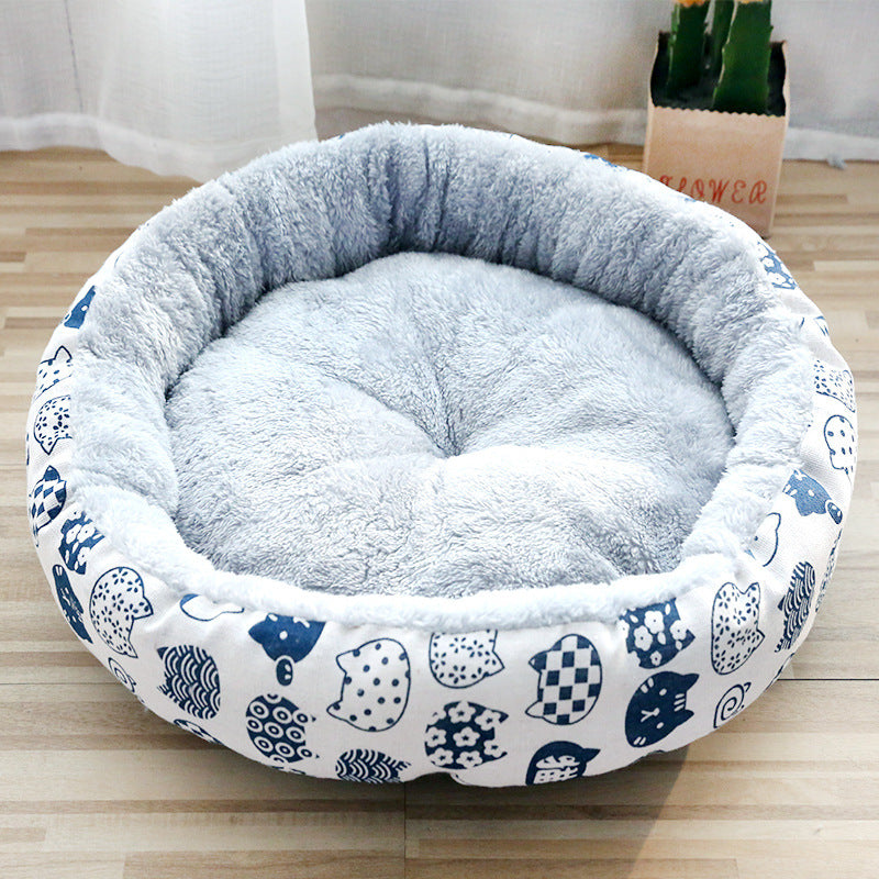 Soft grey plush pet bed with raised edges and white outer fabric printed with blue cat faces