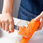 Person peeling a large fresh carrot with a transparent vegetable peeler over white countertop