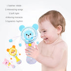 Smiling baby holding colorful bear-shaped musical rattle toy with teether nibble and waving maracas