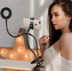 Young woman using flexible ring light and phone holder with clamp on table for video recording