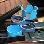 Blue foldable car cup holder attached near black leather handbrake on car console