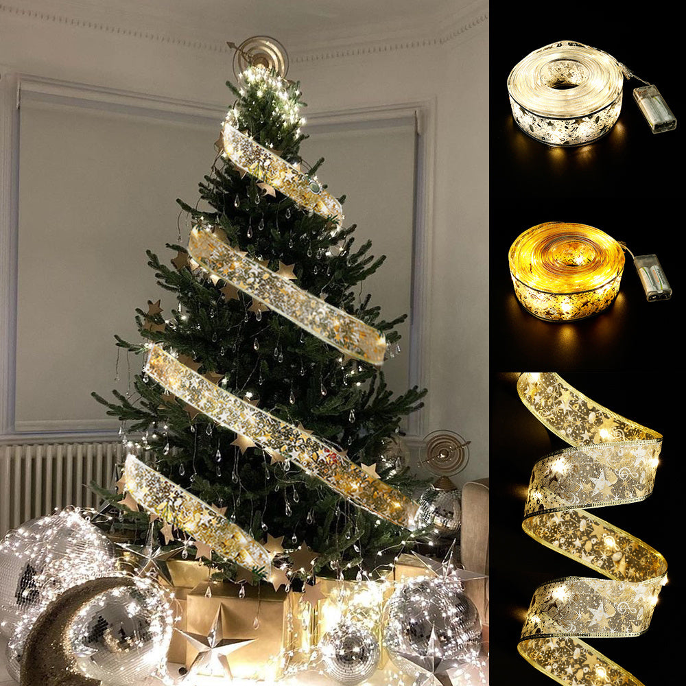 Decorated Christmas tree with gold star ribbon and fairy lights, surrounded by silver ornaments and gifts